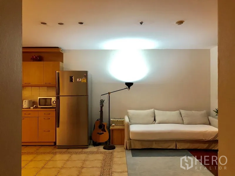 คอนโด ให้เช่าในPathum Wan, Bangkok - มุมพักผ่อนมีโซฟาสีขาว โคมไฟตั้งพื้น และตู้เย็นสแตนเลส