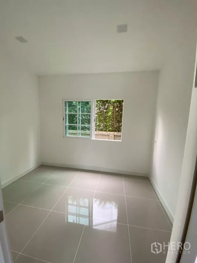 Detached House for rent in Bang Phli, Samut Prakan - Spare room with glossy tiled floor and garden-view windows.