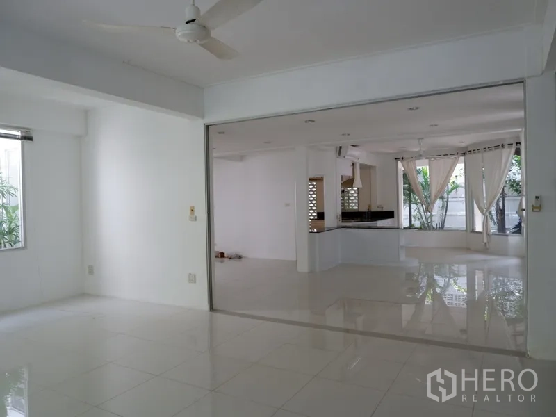Detached House for rent in Khlong Toei, Bangkok - Flexible family room with wide opening to the kitchen and polished white tiles.