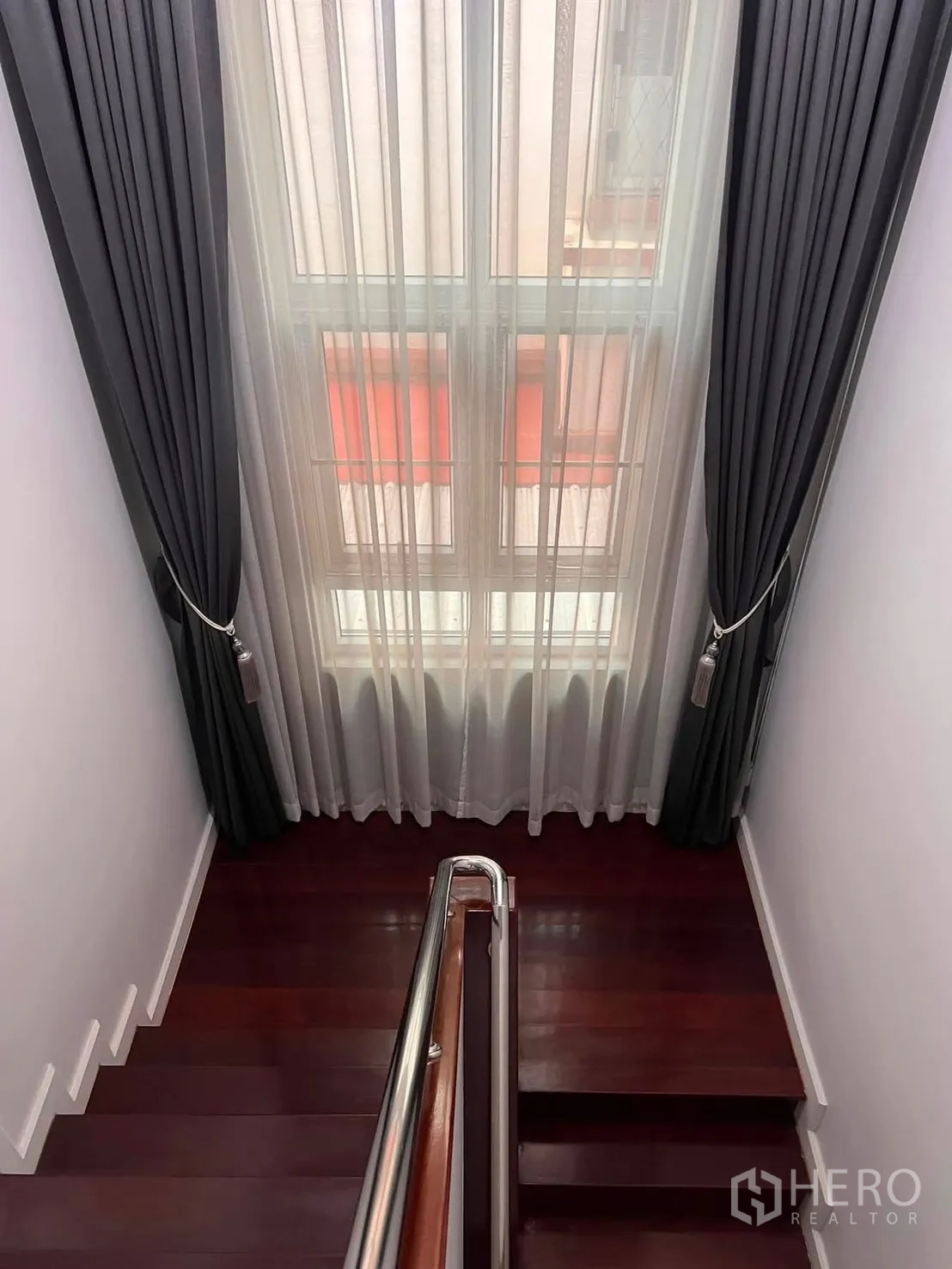 Detached House for rent in Watthana, Bangkok - Staircase with wooden steps and a tall window dressed with sheer and blackout curtains.