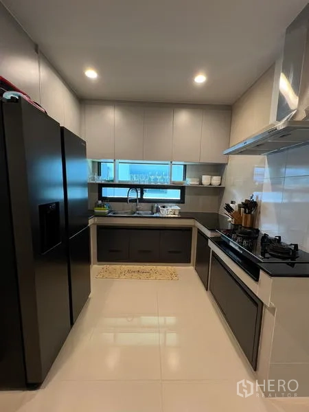 Detached House for rent in Bang Kapi, Bangkok - Fitted kitchen with glossy cabinetry, double-door fridge, sink and gas hob.