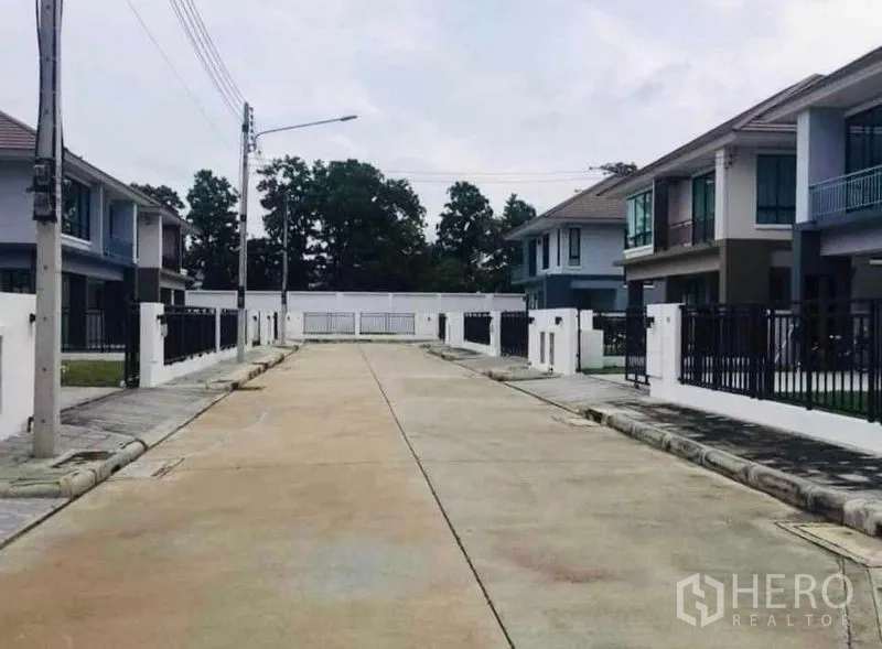 Detached House for rent or sale in Thanyaburi, Pathum Thani - Quiet gated street inside the housing estate lined with modern two-storey homes.