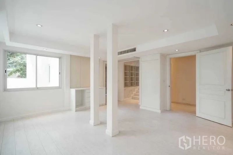 บ้าน ขายในWatthana, Bangkok - พื้นที่นั่งเล่นแบบเปิดโล่งโทนสีขาว มีเสา หน้าต่าง และตู้บิลท์อิน