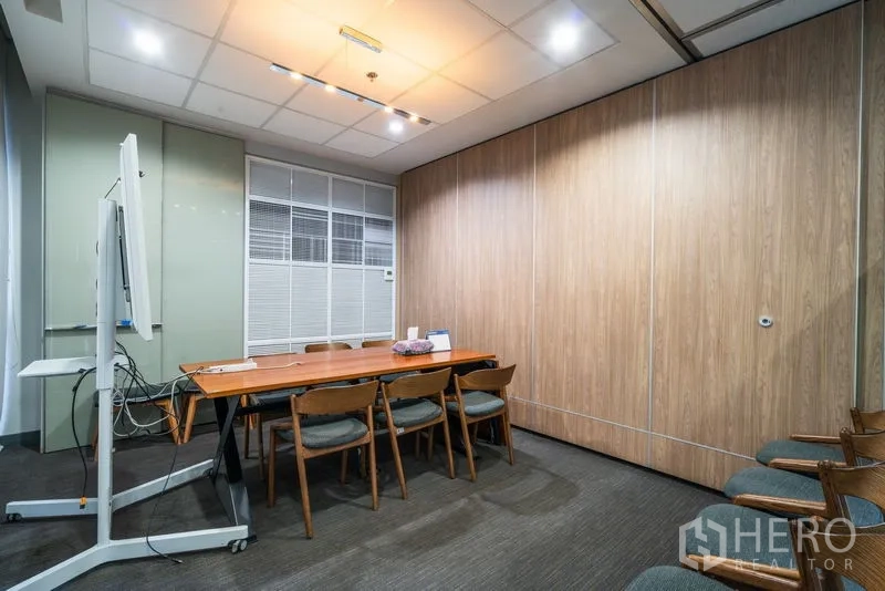 Office Space for rent - Private meeting room with wood table, chairs, and movable partition wall.