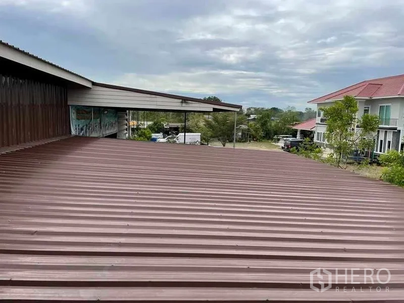 คลังสินค้า ให้เช่าหรือขายในPathum Thani - หลังคาเมทัลชีทโกดัง มองเห็นบ้านพักใกล้เคียง