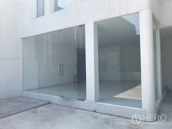 零售空间 出租在Khlong Toei, Bangkok - 临街玻璃店面，双开玻璃门与明亮白色外墙。