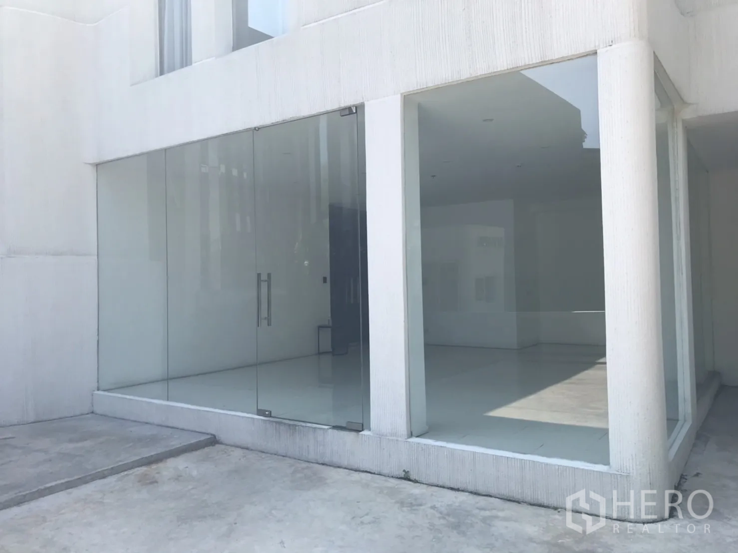 零售空间 出租在Khlong Toei, Bangkok - 临街玻璃店面，双开玻璃门与明亮白色外墙。