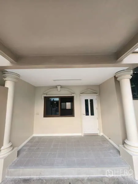 Townhouse for rent in Wang Thonglang, Bangkok - Covered carport and entrance porch with columns and white door.