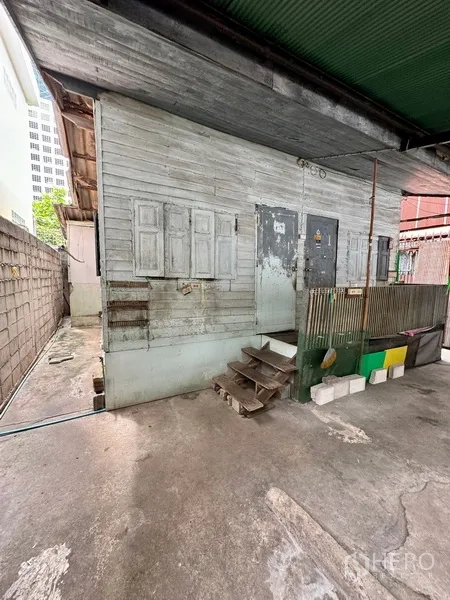 Shophouse for rent in Bang Rak, Bangkok - Covered concrete yard with an old wooden outbuilding inside the property.