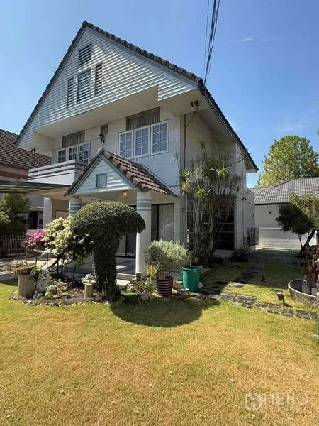 Detached House for rent in Bang Kapi, Bangkok - Side lawn and tall gable‑roof house with landscaped garden.