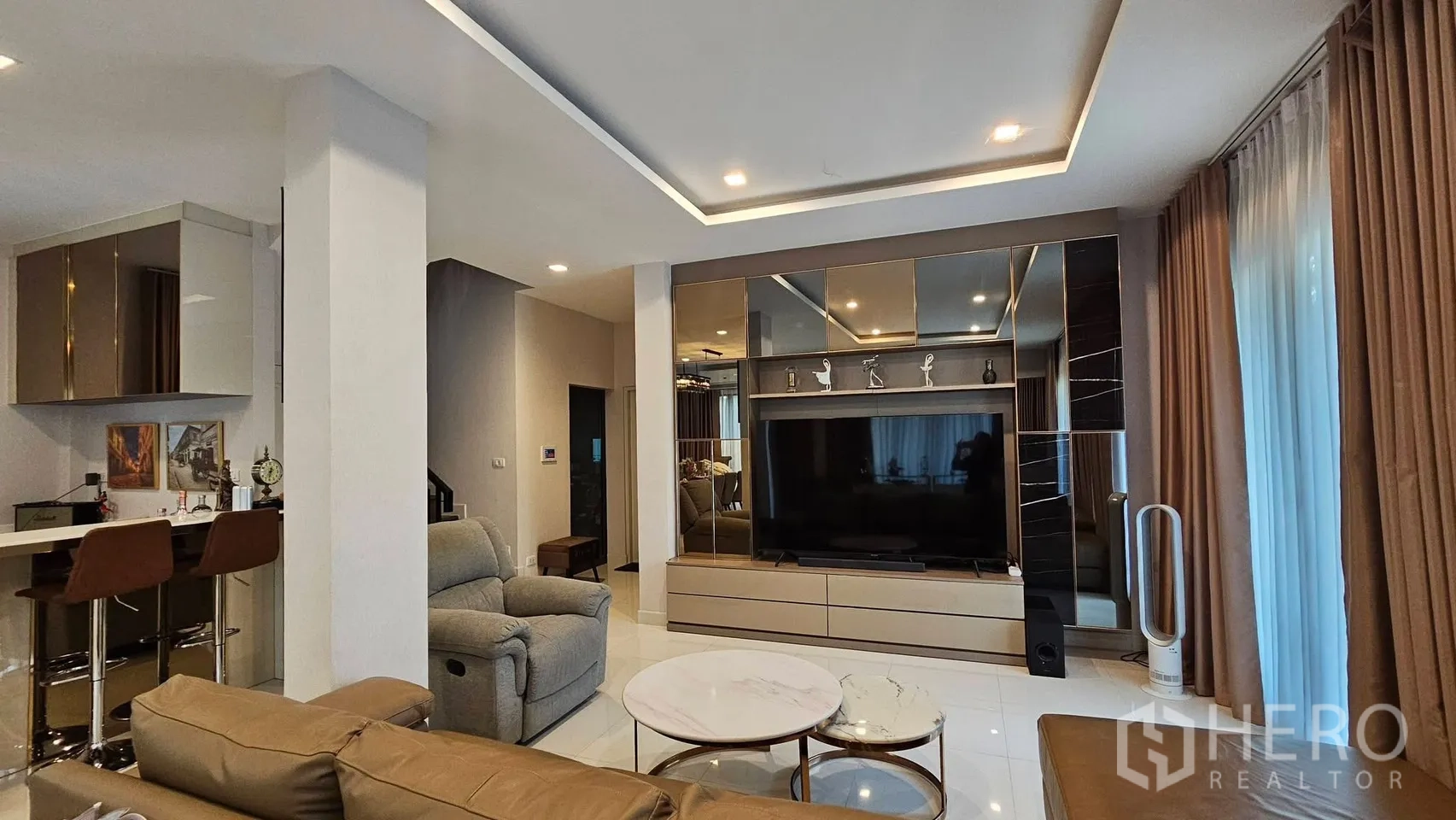 บ้านเดี่ยว for rent in Saphan Sung, Bangkok - ห้องนั่งเล่นมีผนังทีวีขนาดใหญ่ โซฟา และไฟฝ้าซ่อน.
