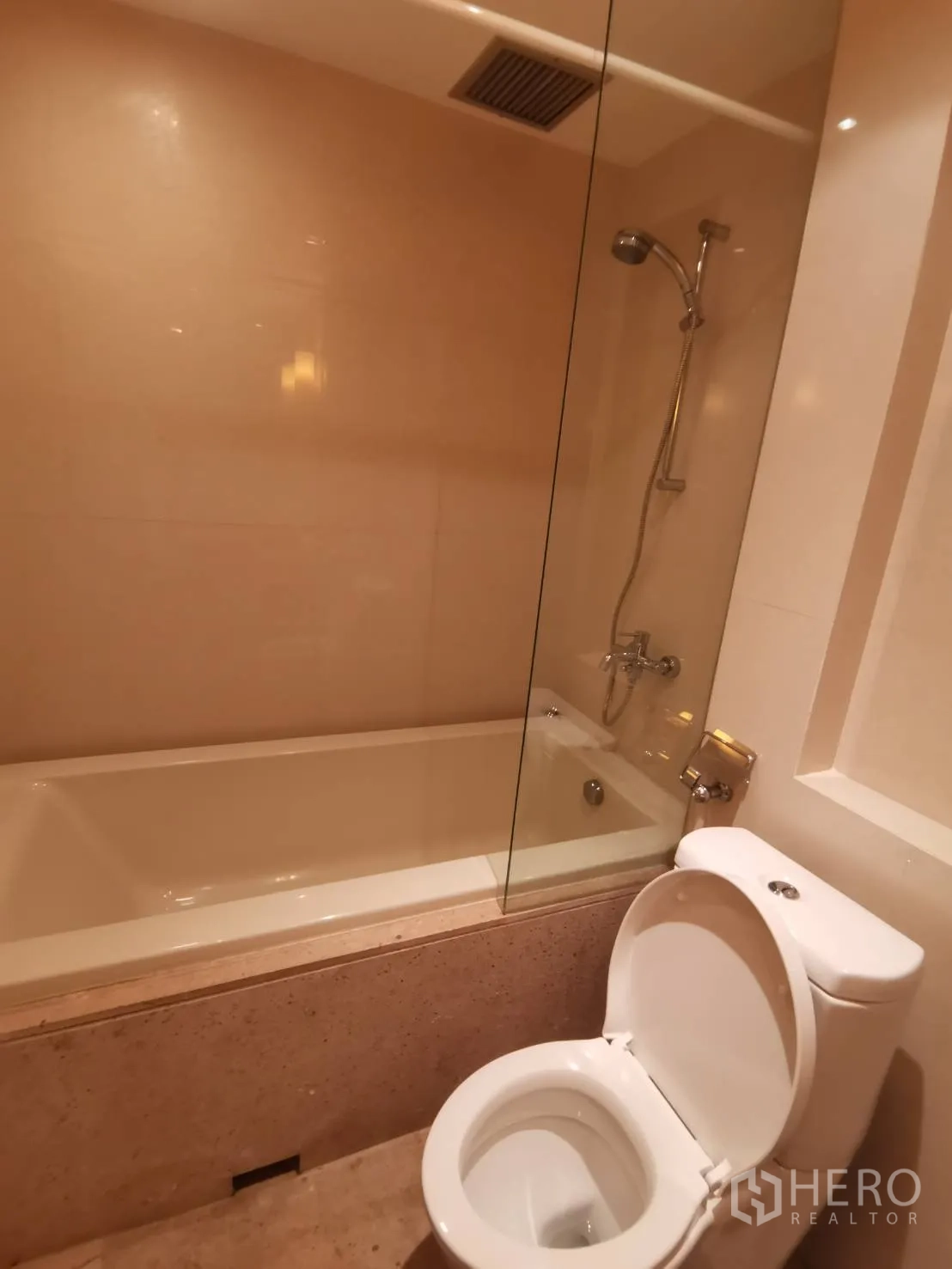 คอนโด ให้เช่าในPathum Wan, Bangkok - ห้องน้ำมีอ่างอาบน้ำกั้นกระจก โถสุขภัณฑ์ และผนังสีเบจ