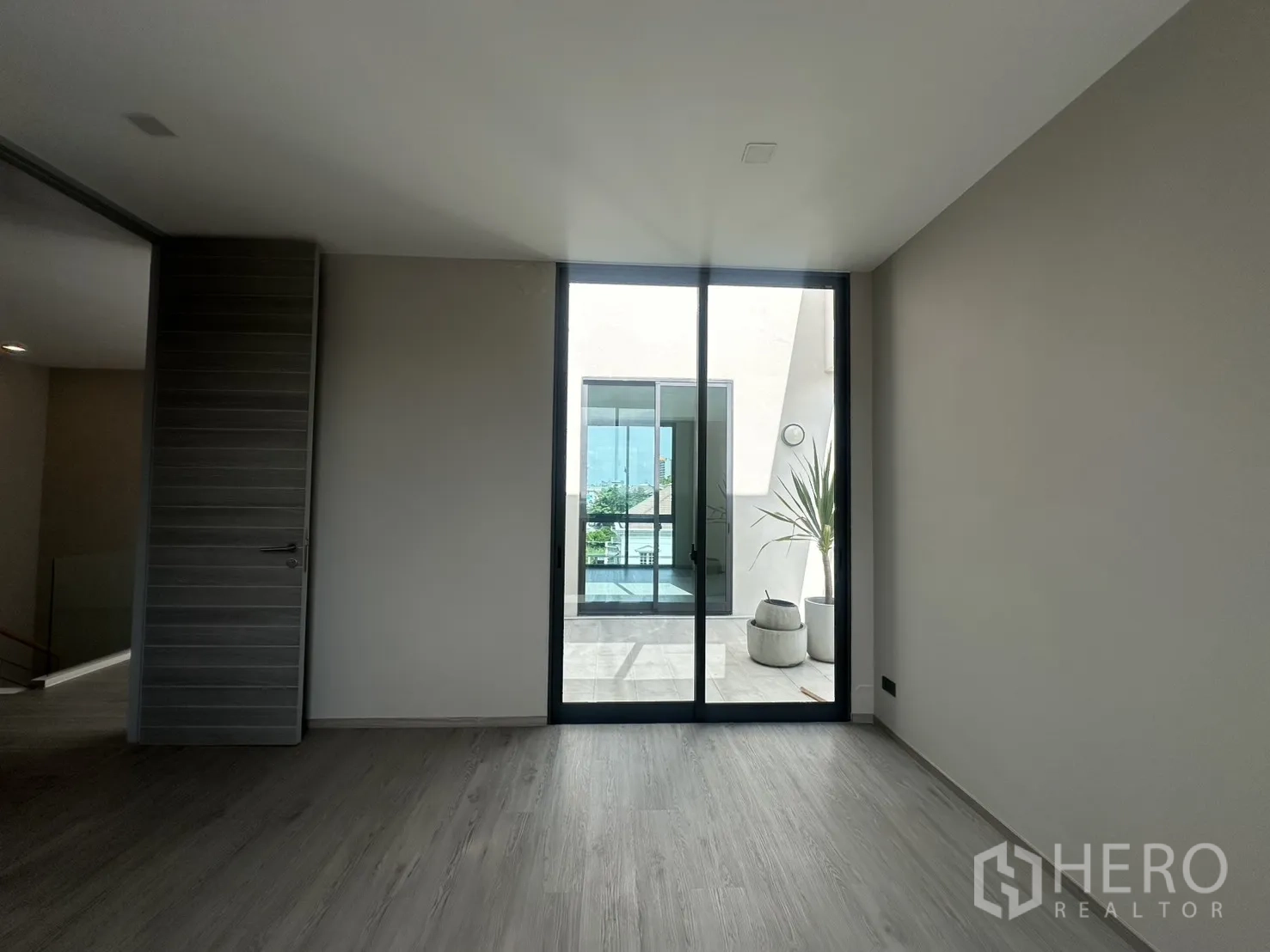 Home Office for rent or sale in Suan Luang, Bangkok - Bedroom or office facing a bright terrace with potted plants.
