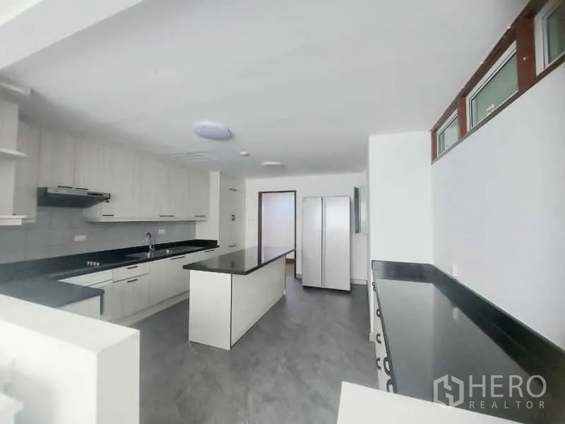 คอนโด ให้เช่าในWatthana, Bangkok - มุมมองครัวอีกด้าน โชว์เคาน์เตอร์ยาว เตา เครื่องดูดควัน และพื้นที่วางตู้เย็น