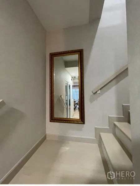 Detached House for rent or sale - Stairway and landing with a large framed mirror and light-colored walls