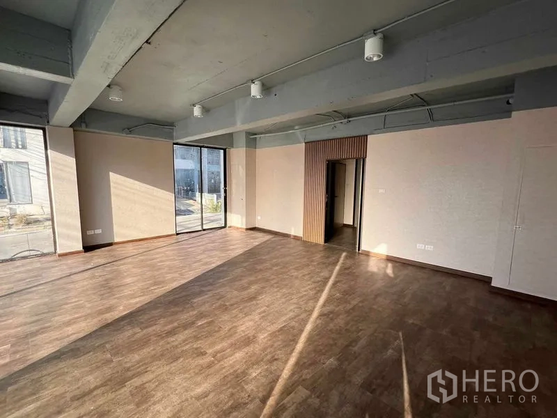 办公空间 出租或出售在Suan Luang, Bangkok - 开放式办公区，落地玻璃与通往小型私密房的入口。