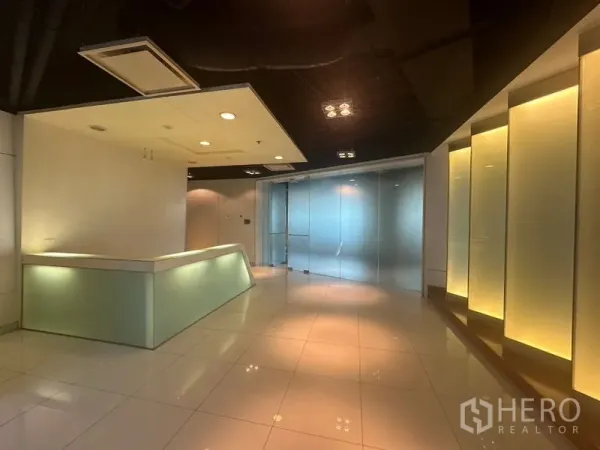Office Space for rent in Khlong Toei, Bangkok - Modern office reception with backlit wall panels and a frosted glass entry.