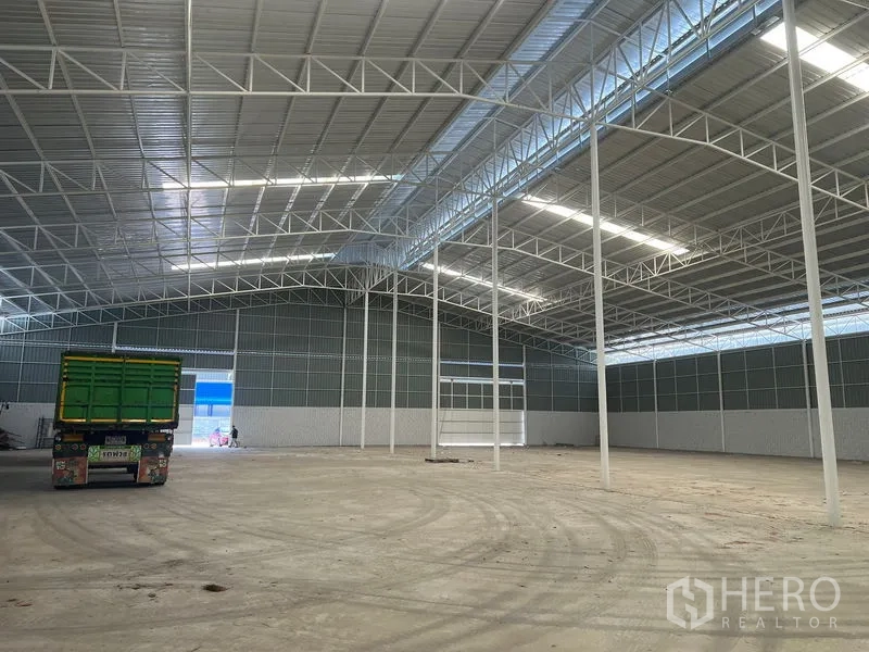 Warehouse for rent in Lat Krabang, Bangkok - Large clear-span warehouse with loading access and a truck near the big sliding door.