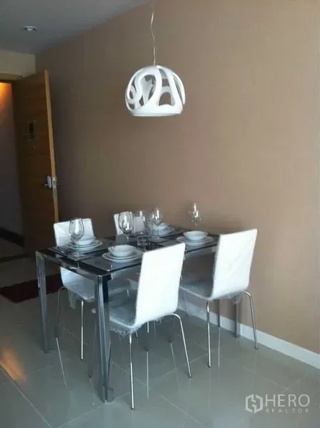 公寓 出售在Ratchathewi, Bangkok - 餐区紧凑，玻璃餐桌搭配四把白色椅子与造型吊灯，米色墙面。