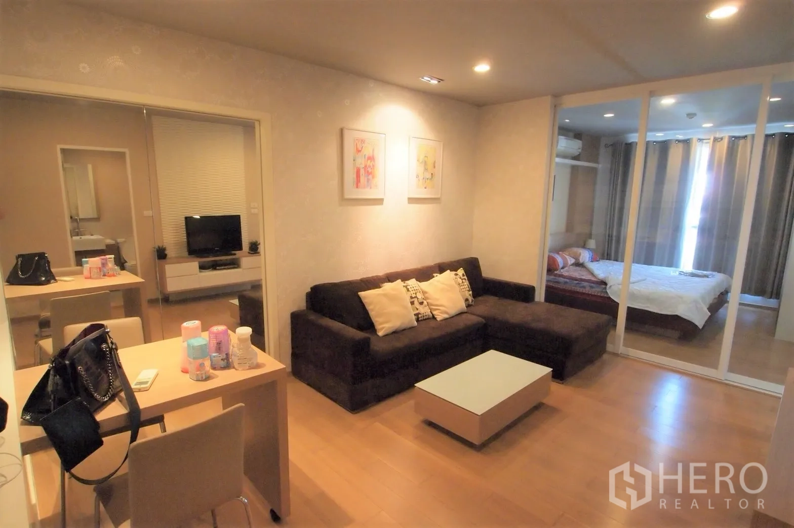 Detached House for rent or sale in Saphan Sung, Bangkok - Family lounge with sectional sofa and glass sliding doors to a bedroom suite