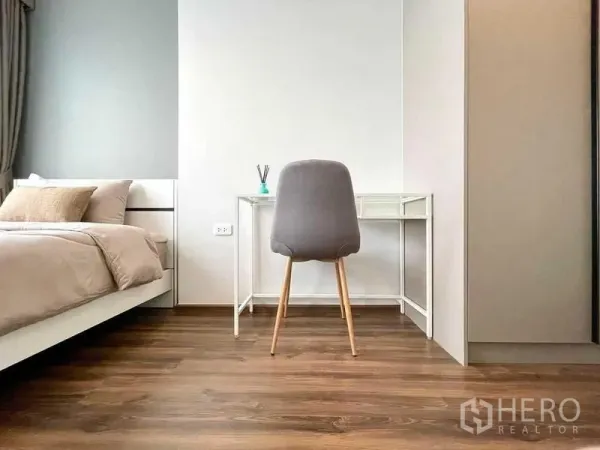 公寓 出租或出售在Phra Khanong, Bangkok - 明亮卧室，配置床、学习桌与暖色木地板。