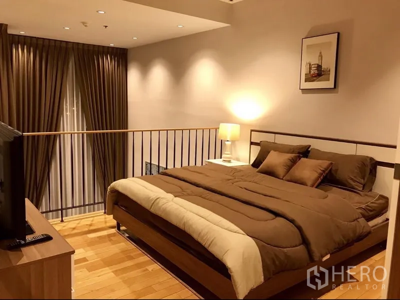 คอนโด ให้เช่าในKhlong Toei, Bangkok - ห้องนอนชั้นลอย เตียงคิงส์ พื้นไม้ โคมไฟหัวเตียง และผ้าม่านทิ้งตัว