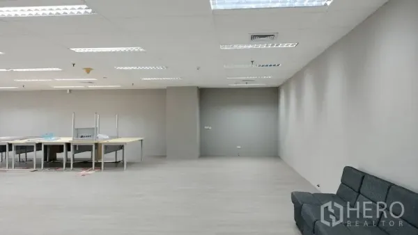 Office Space for rent or sale in Pathum Wan, Bangkok - Spacious open-plan office with grey walls, sofa and work tables under LED lighting.