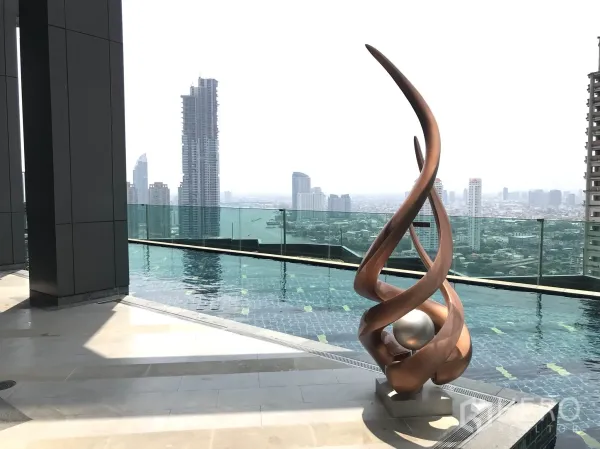 Condominium for rent or sale in Sathon, Bangkok - Rooftop infinity pool with a modern bronze sculpture and Bangkok skyline views in Sathon.