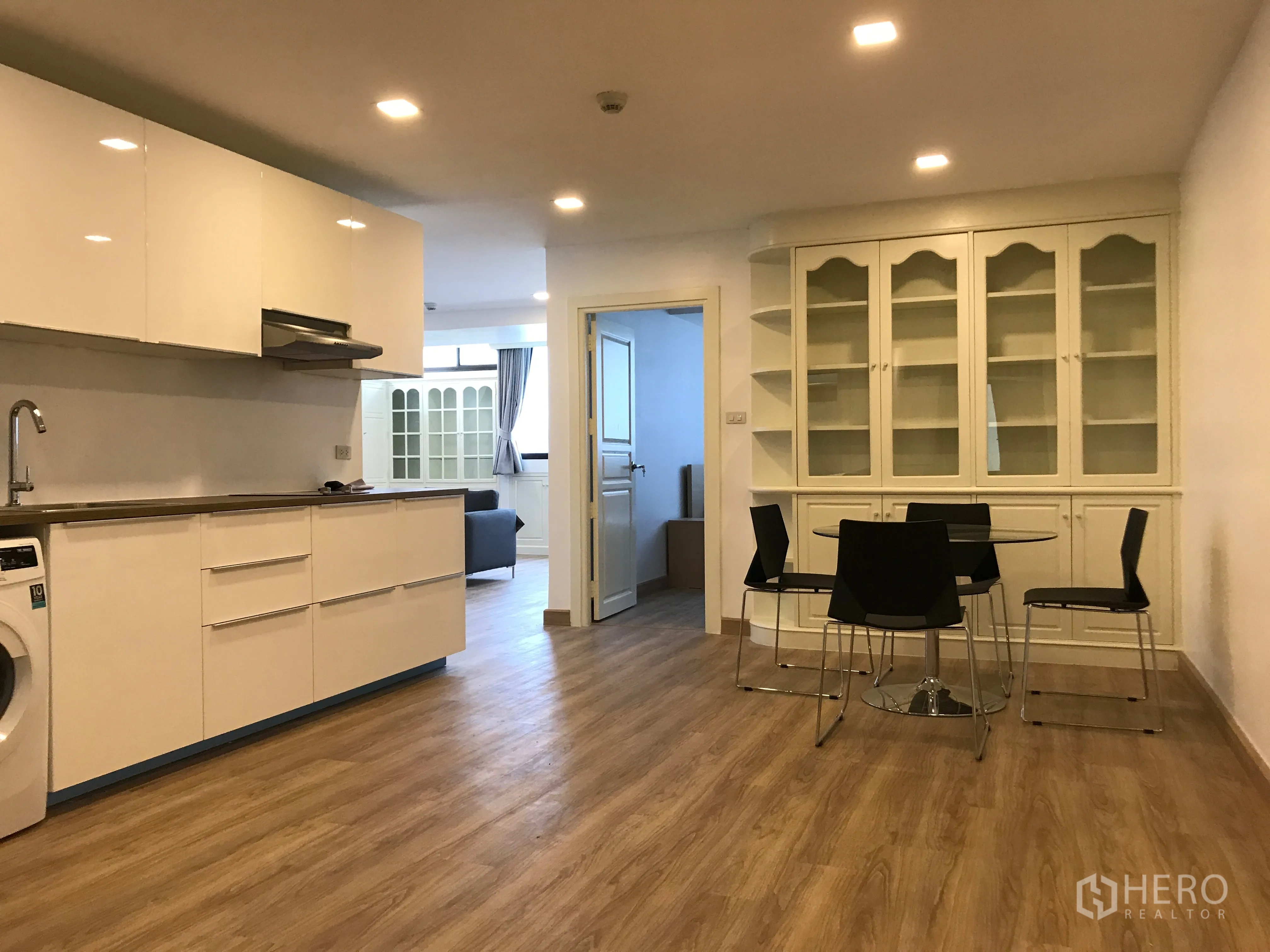 公寓 出售在Watthana, Bangkok - 开放式现代厨房与用餐区，白色橱柜和木地板