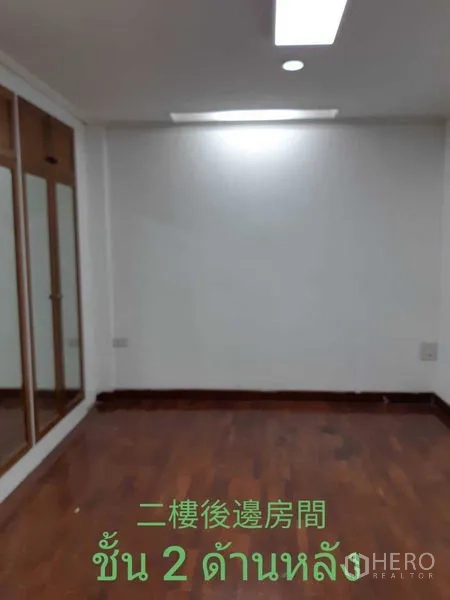 Townhouse for rent in Watthana, Bangkok - Bedroom with wooden flooring and mirrored wardrobe.