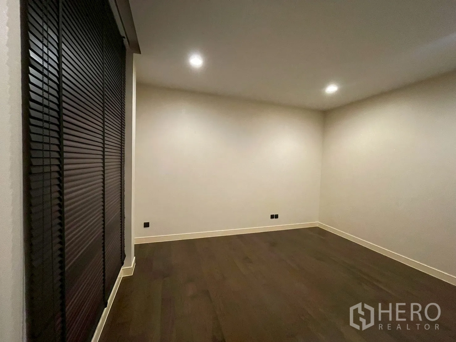 Detached House for rent in Bang Kapi, Bangkok - Spacious room with dark timber floors and recessed ceiling lights.