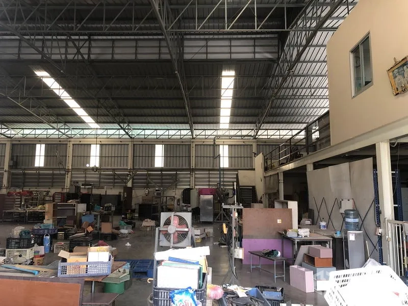 Factory for sale in Khlong Luang, Pathum Thani - High-clearance factory interior with steel trusses, skylights and a mezzanine office.