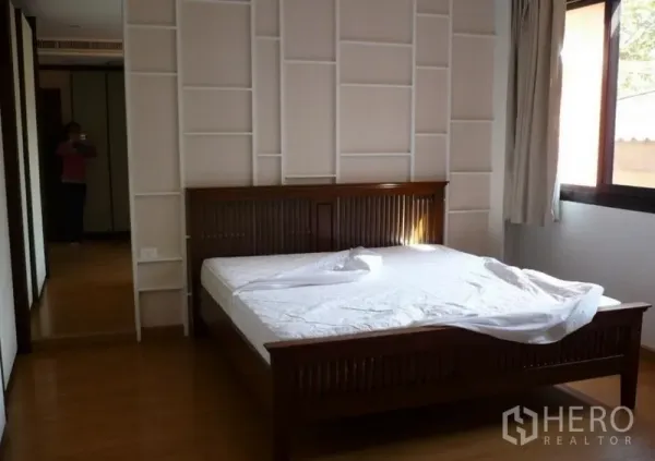 บ้าน ให้เช่าในKhlong Toei, Bangkok - ห้องนอนสว่าง เตียงไม้ ผนังตกแต่งลวดลาย และหน้าต่างรับแสงธรรมชาติ