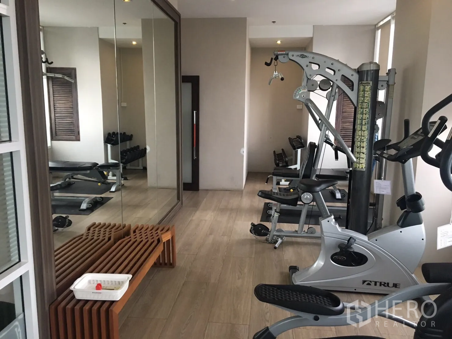 คอนโด ให้เช่าในPhaya Thai, Bangkok - ห้องฟิตเนสคอนโด มีเครื่องคาดิโอ ดัมเบล กระจกบานใหญ่ และพื้นลายไม้โทนอ่อน