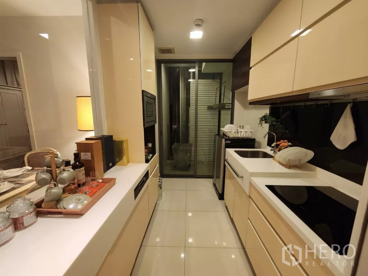 คอนโด ให้เช่าในPhra Khanong, Bangkok - ครัวแบบกัลเลย์ เคาน์เตอร์สองฝั่ง เชื่อมต่อสู่ระเบียง/พื้นที่ซักล้าง