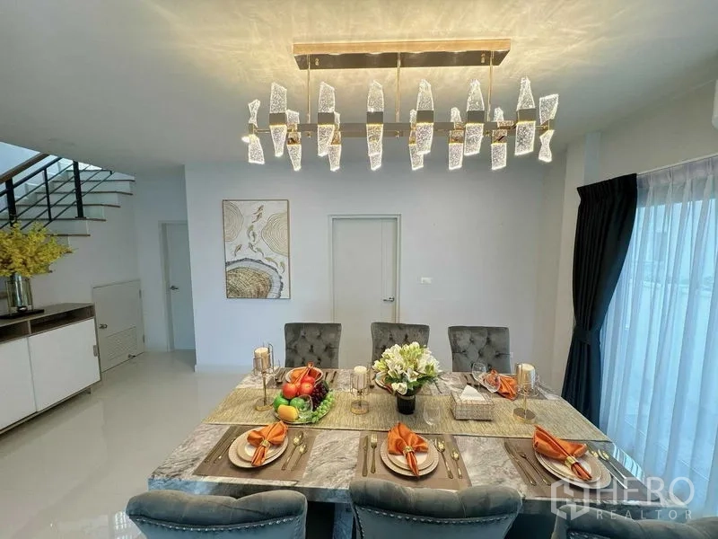 Detached House for rent or sale - Dining table arranged for a meal under a crystal chandelier in a bright room.