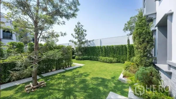 Detached House for rent or sale in Saphan Sung, Bangkok - Landscaped private garden with lush lawn, trees and tall privacy hedges.