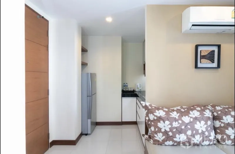 房间 出租在Bang Rak, Bangkok - 入口一隅，冰箱、层架与部分沙发，采光充足的起居区。