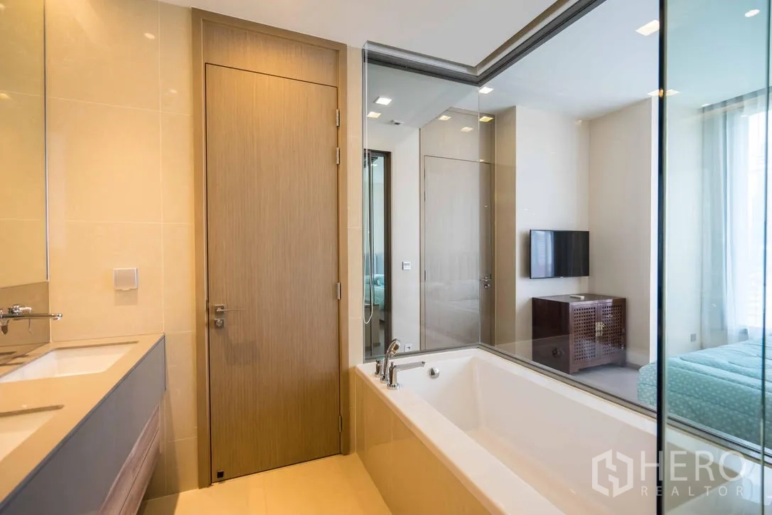 Condominium for rent in Watthana, Bangkok - Contemporary bathroom with soaking tub, double vanity and glass wall to bedroom.