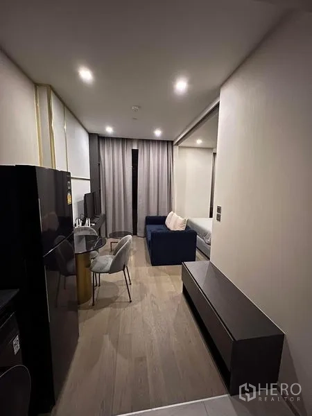 Condominium for rent in Watthana, Bangkok - Night view living room with balcony doors and city lights outside.