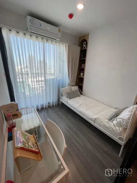 คอนโด ให้เช่า - ห้องนอนรองหรือห้องทำงาน เตียงเดย์เบด โต๊ะทำงาน หน้าต่างบานใหญ่พร้อมม่านโปร่ง