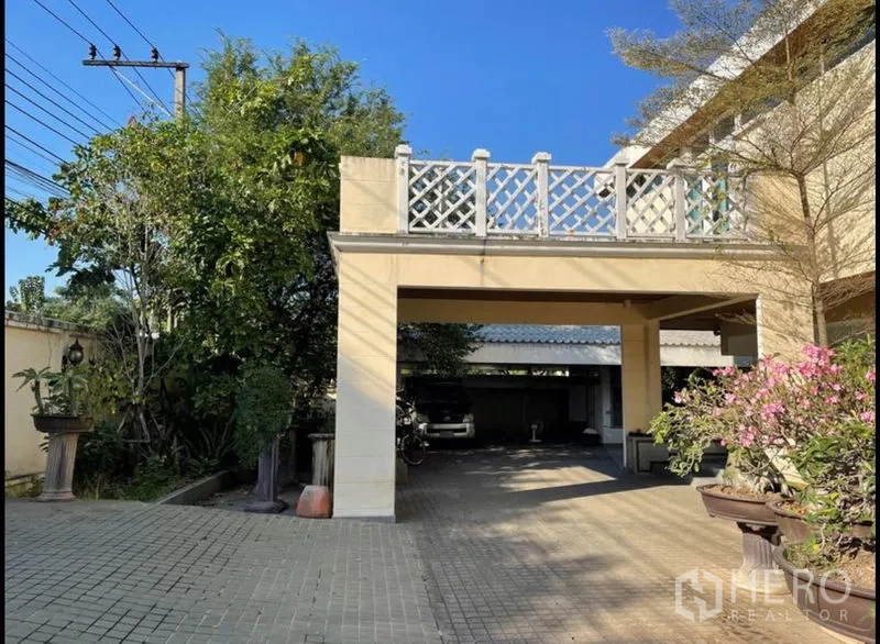 Detached House for rent in Khlong Toei, Bangkok - Covered carport with wide paved driveway and planters beside the residence.