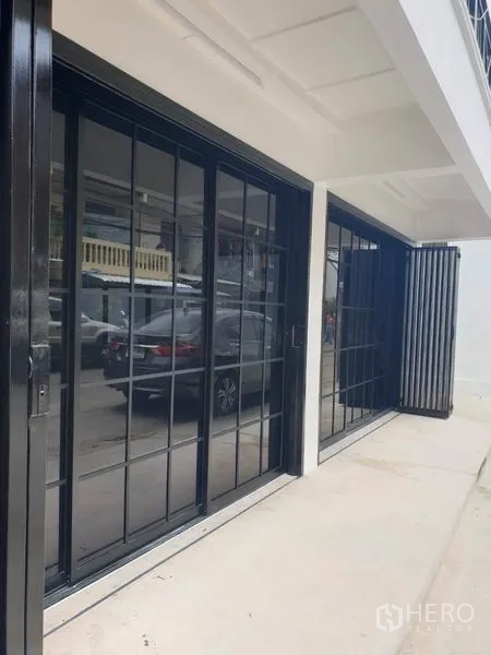 带办公室的家 出租或出售在Bang Na, Bangkok - 一层临街黑框推拉落地窗。