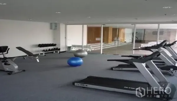 คอนโด ให้เช่าในPhaya Thai, Bangkok - ห้องฟิตเนสสว่างพร้อมลู่วิ่ง ม้านั่งยกน้ำหนัก และดัมเบล หลังผนังกระจก