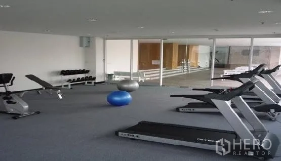 คอนโด ให้เช่าในPhaya Thai, Bangkok - ห้องฟิตเนสสว่างพร้อมลู่วิ่ง ม้านั่งยกน้ำหนัก และดัมเบล หลังผนังกระจก