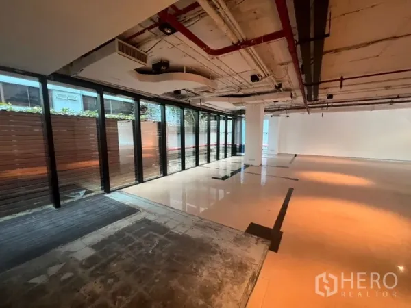 Office Space for rent in Watthana, Bangkok - Open workspace lined with floor-to-ceiling glass looking onto a private screened terrace.