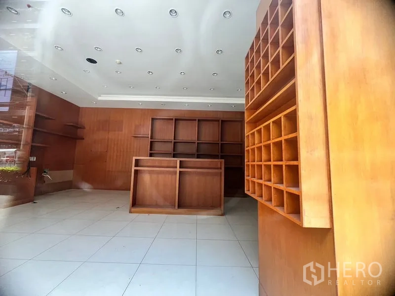 พื้นที่ขายปลีก ให้เช่าในKhlong Toei, Bangkok - ภายในร้านพร้อมชั้นวางไม้บิวท์อิน เคาน์เตอร์แสดงสินค้า และพื้นกระเบื้องสีขาวพร้อมดาวน์ไลต์