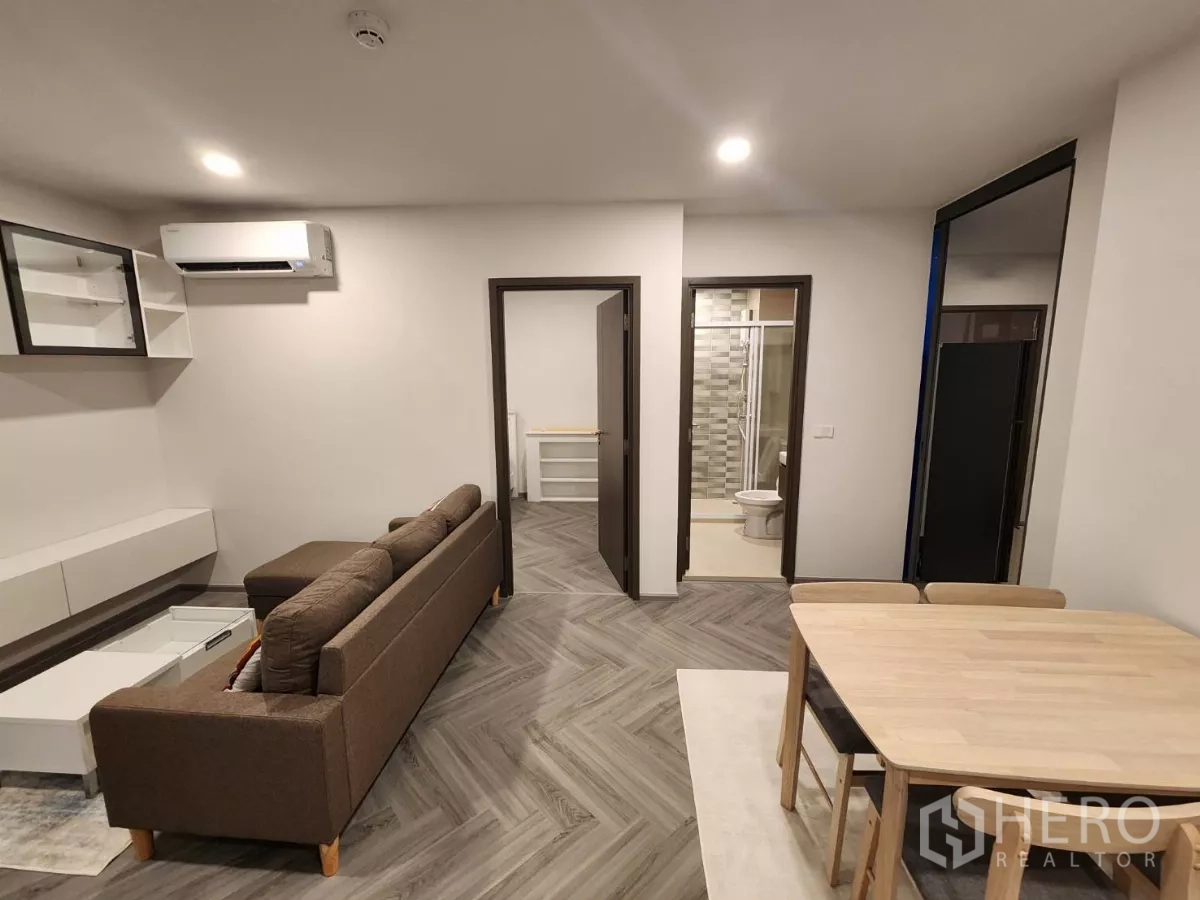 Townhouse for rent in Khlong Toei, Bangkok - Living area facing bedroom and bathroom with wood herringbone flooring.