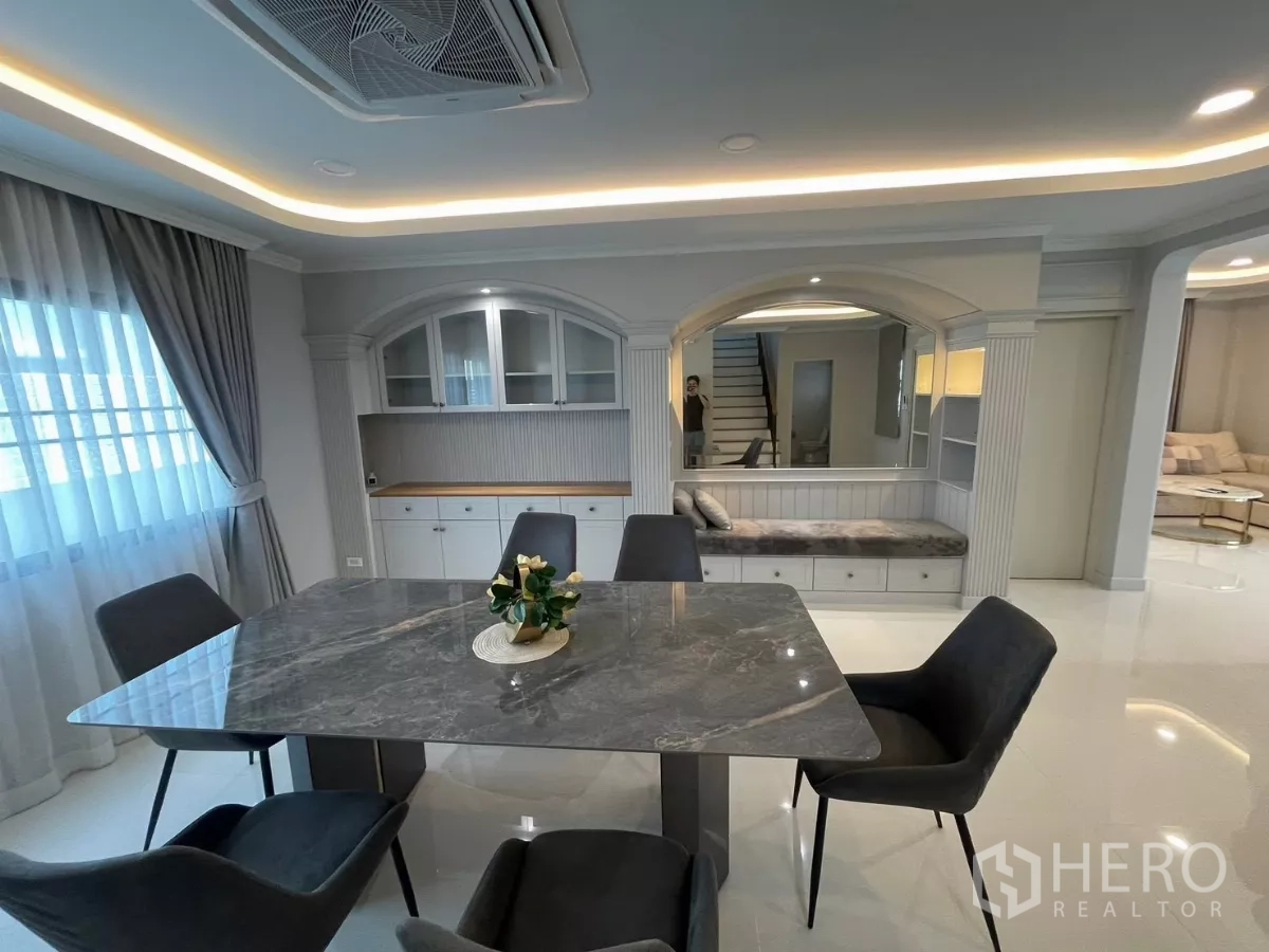 独立式住宅 出租在Bang Phli, Samut Prakan - 餐厅配大理石桌、镜面特色墙与内置长椅。