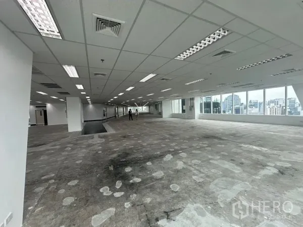 Office Space for rent - Deep floor plate with ceiling air vents, fluorescent fixtures and broad window line.